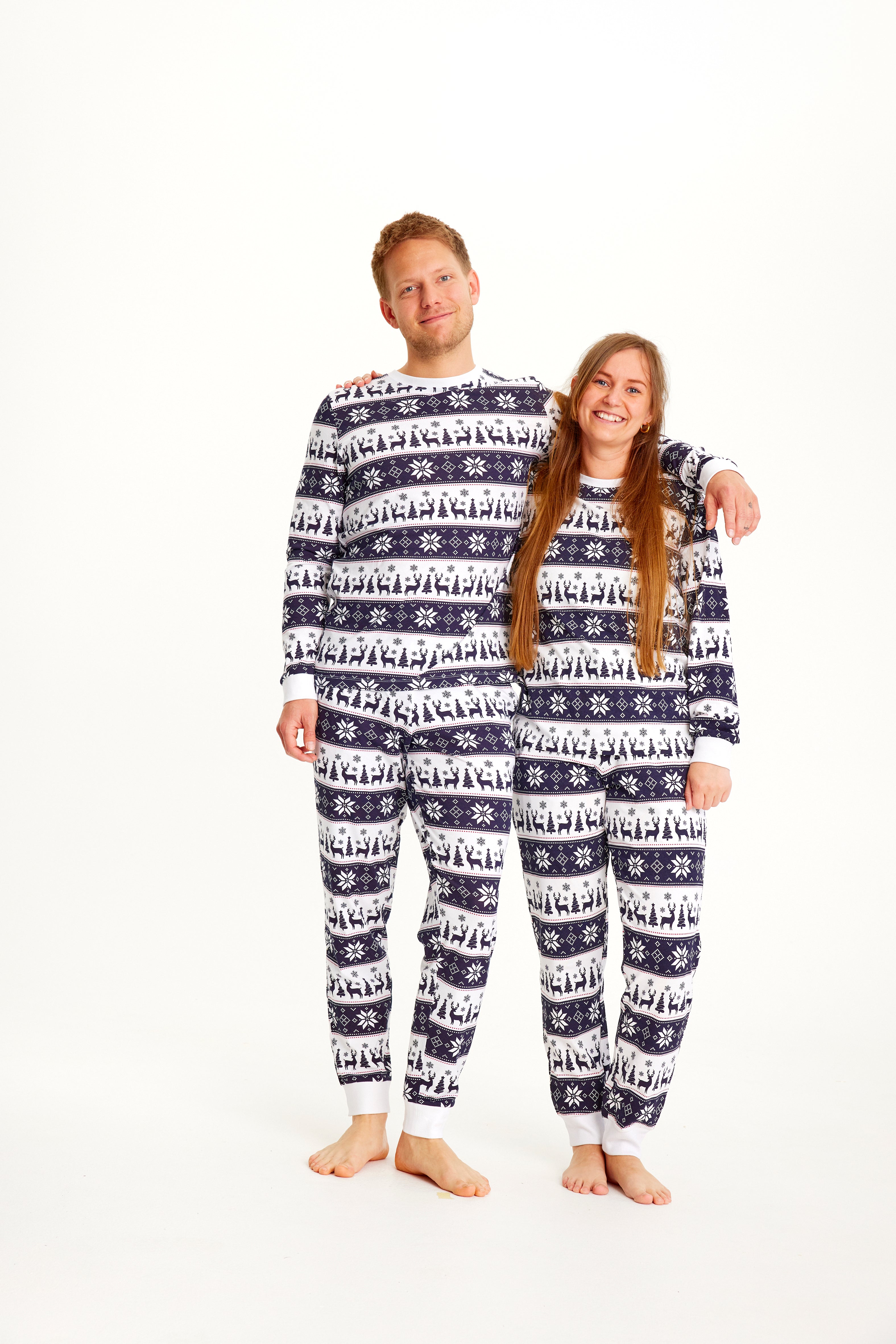 Un couple portant un pyjama de Noël à rayures blanches et bleues.